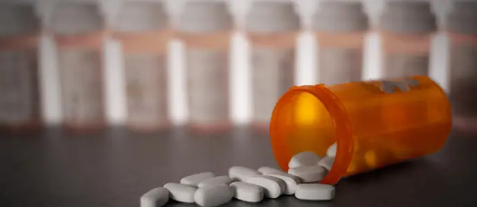 pill jar tipped over with pills falling out