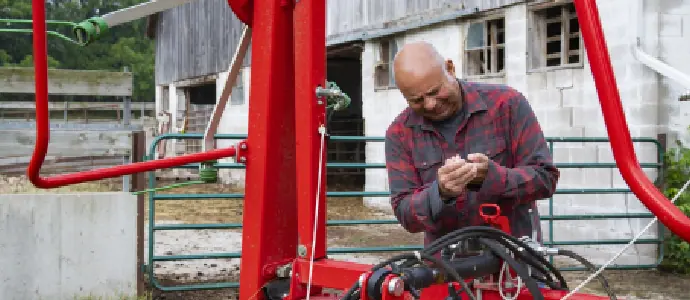 man on farm holding his hand in pain